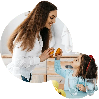 Mãe e filha preparando uma fruta juntas na cozinha de casa